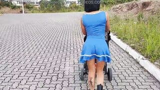 Delightful mother inside blue dress without lingerie during street walk.